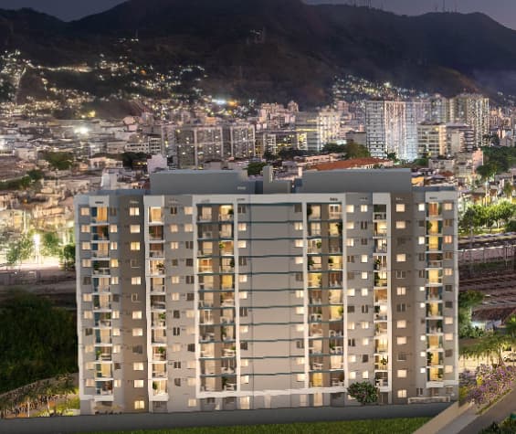 Vista noturna da fachada de edifício residencial com varandas iluminadas.